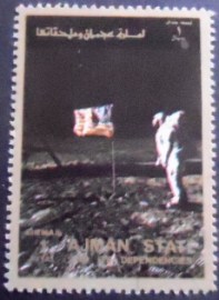 Selo de postal de Ajman de 1973 Astronaut in front of flag on the moon